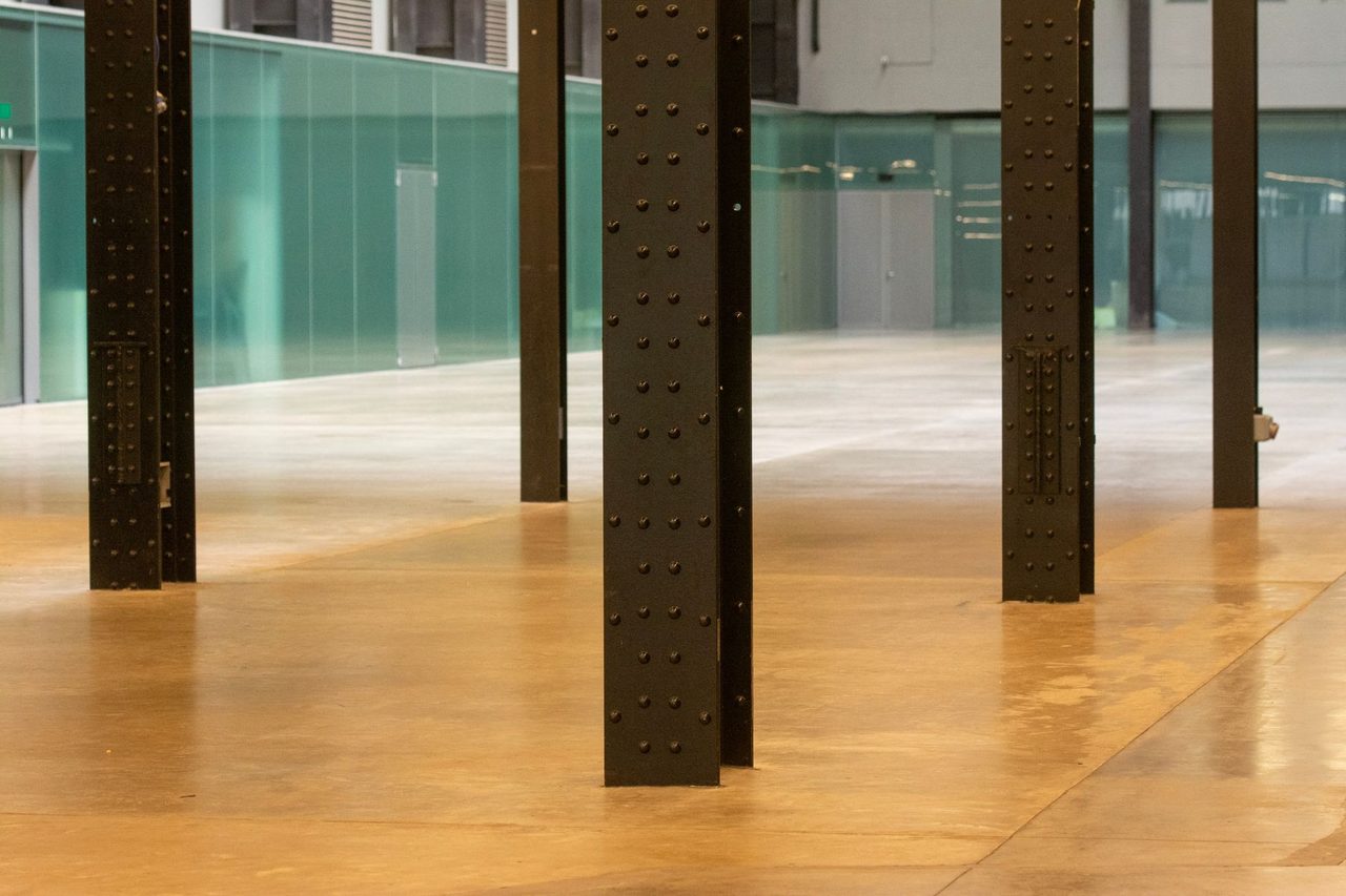 Modern industrial space with steel pillars and a polished concrete floor, perfect for versatile use.